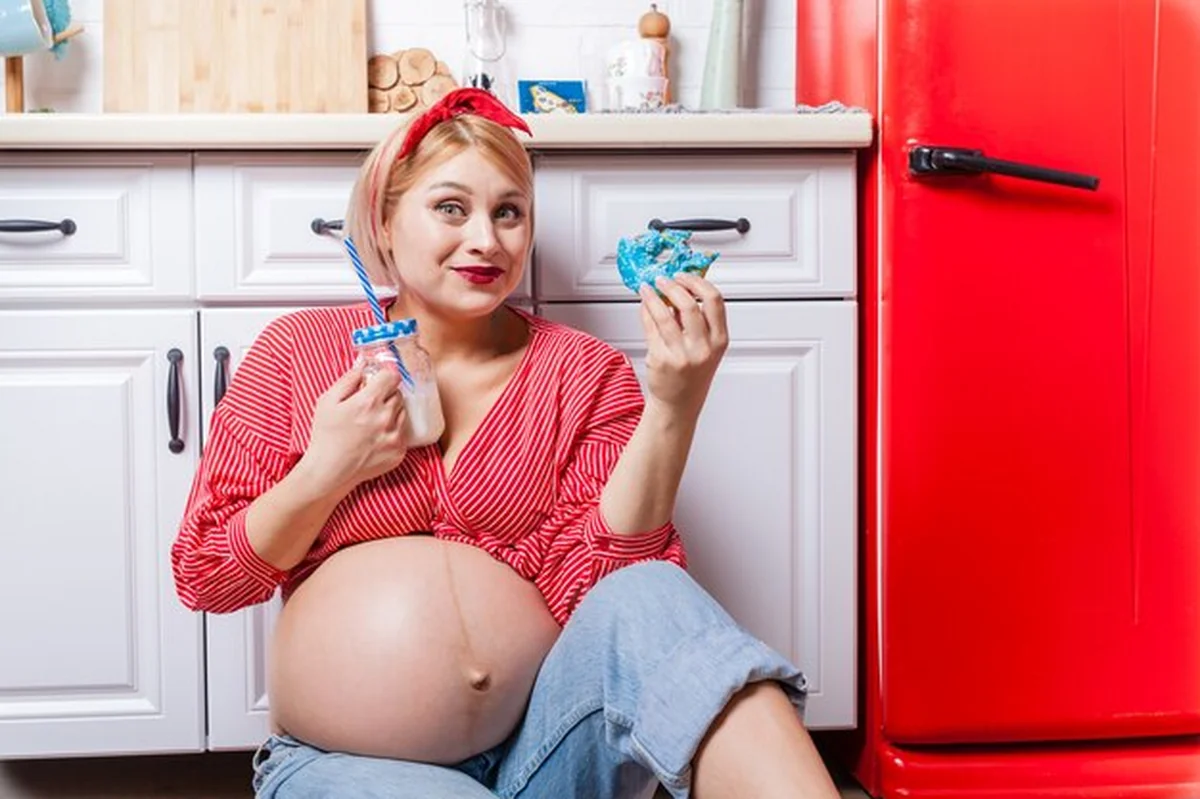 Kobieta w ciąży je pączka