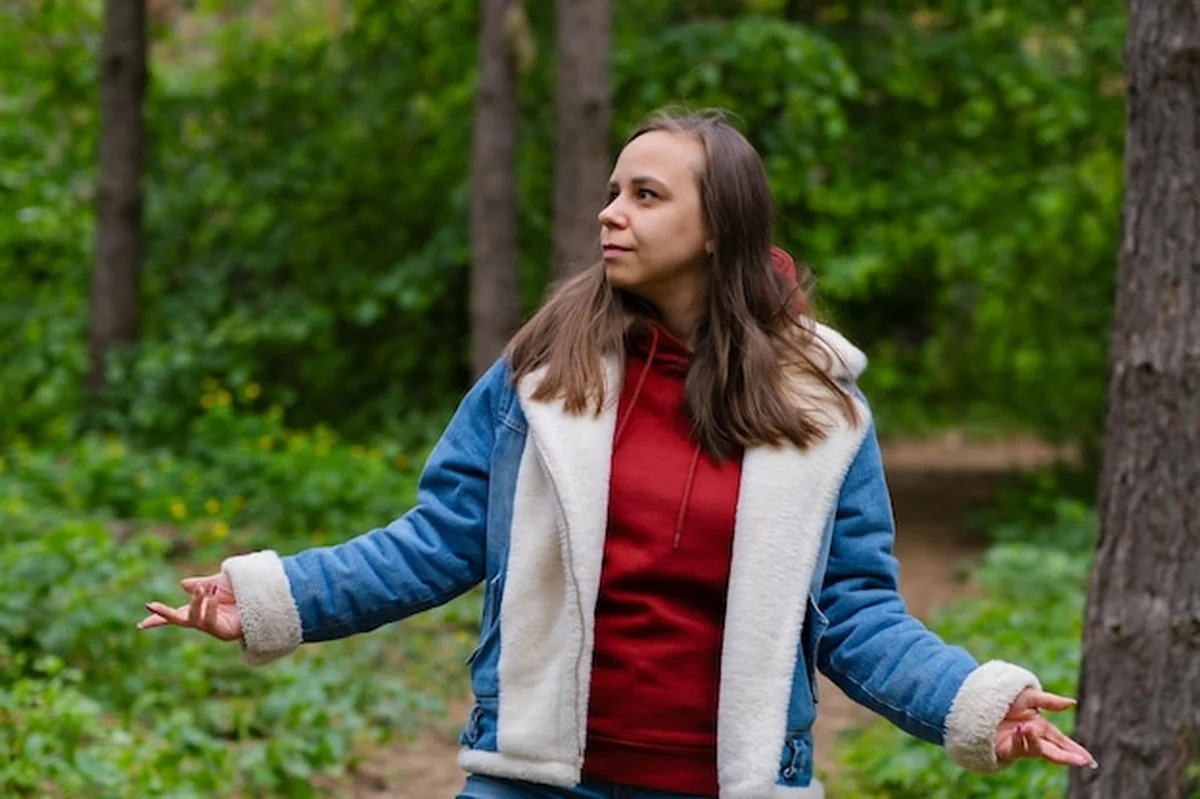 Kobieta tańcząca energicznie w lesie, emanująca pewnością siebie i radością