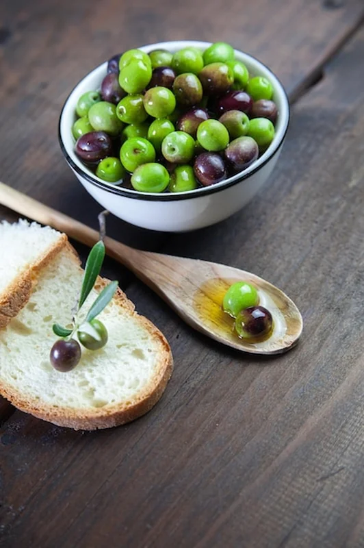 Zielone oliwki i chleb na stole z wysokiego kąta widoku
