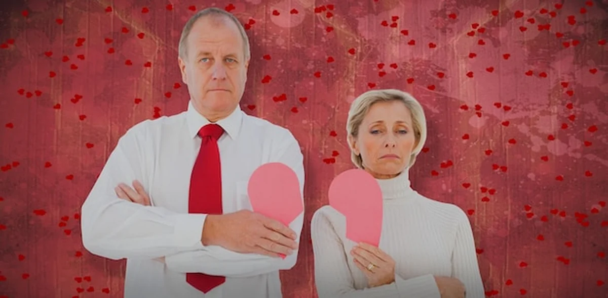 Starsza para trzymająca złamane różowe serce