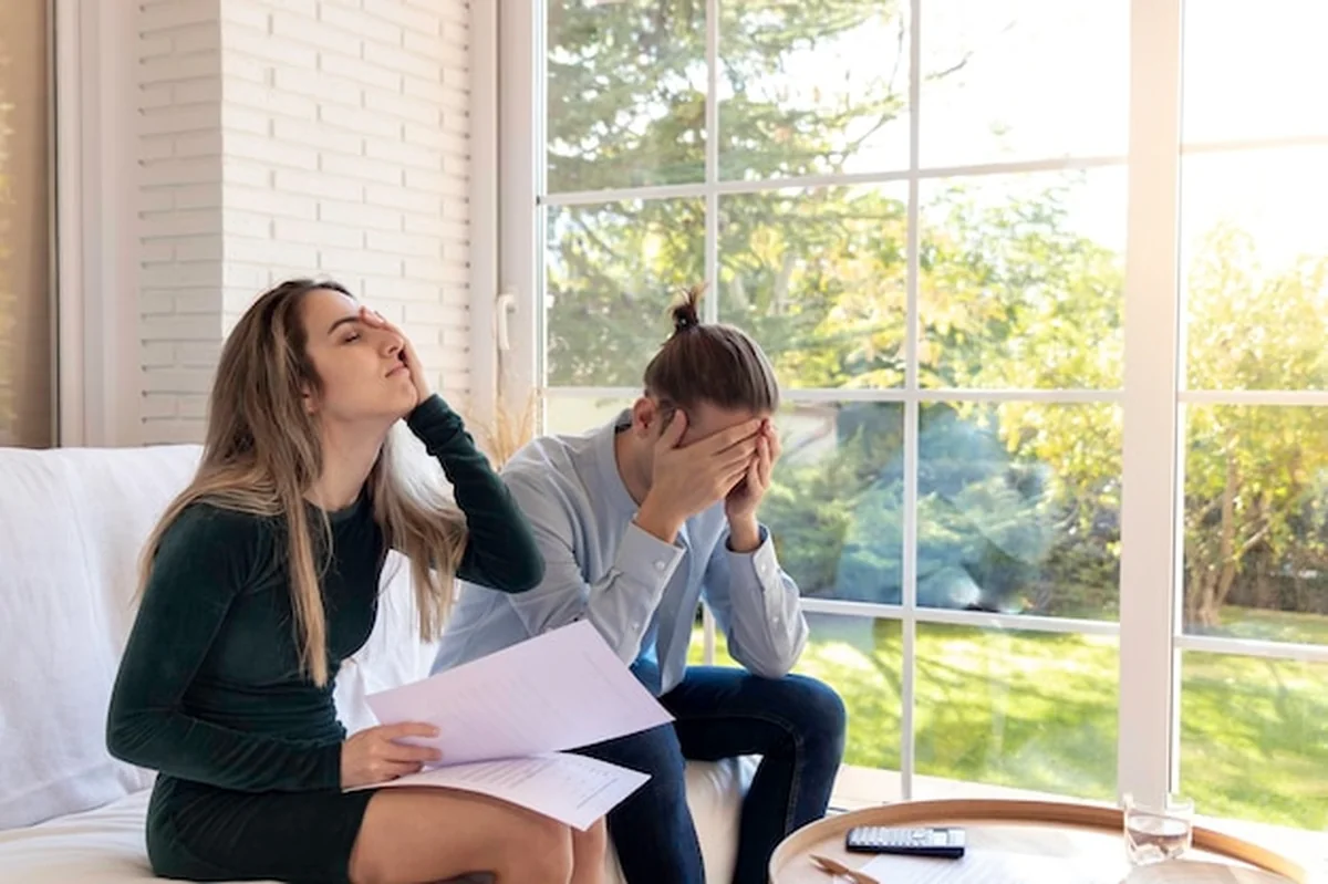 Młoda para czytająca dokumenty, zszokowana i zmartwiona