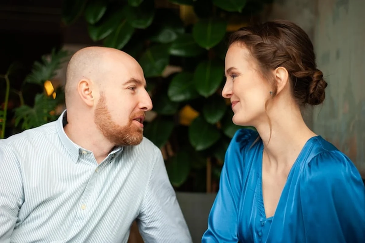 Mężczyzna i kobieta siedzą razem. Jeden ma łysą głowę