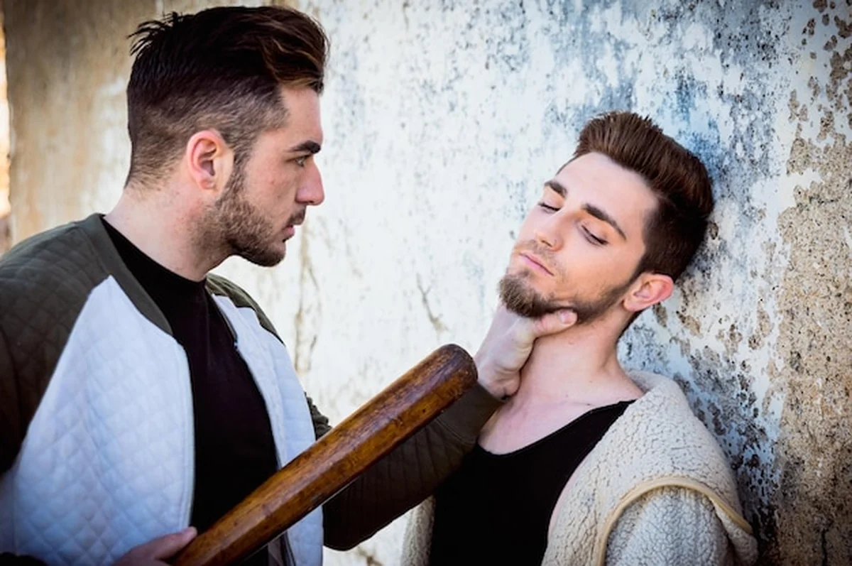 Mężczyzna trzymający kij przy ścianie