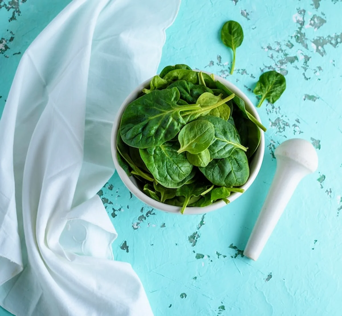 Surowy zielony szpinak w białej ceramicznej misce