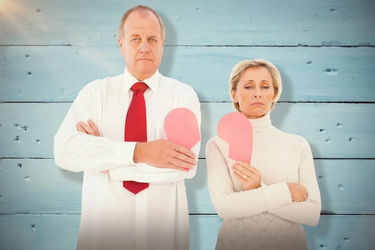 Starsza para trzymająca złamane różowe serce