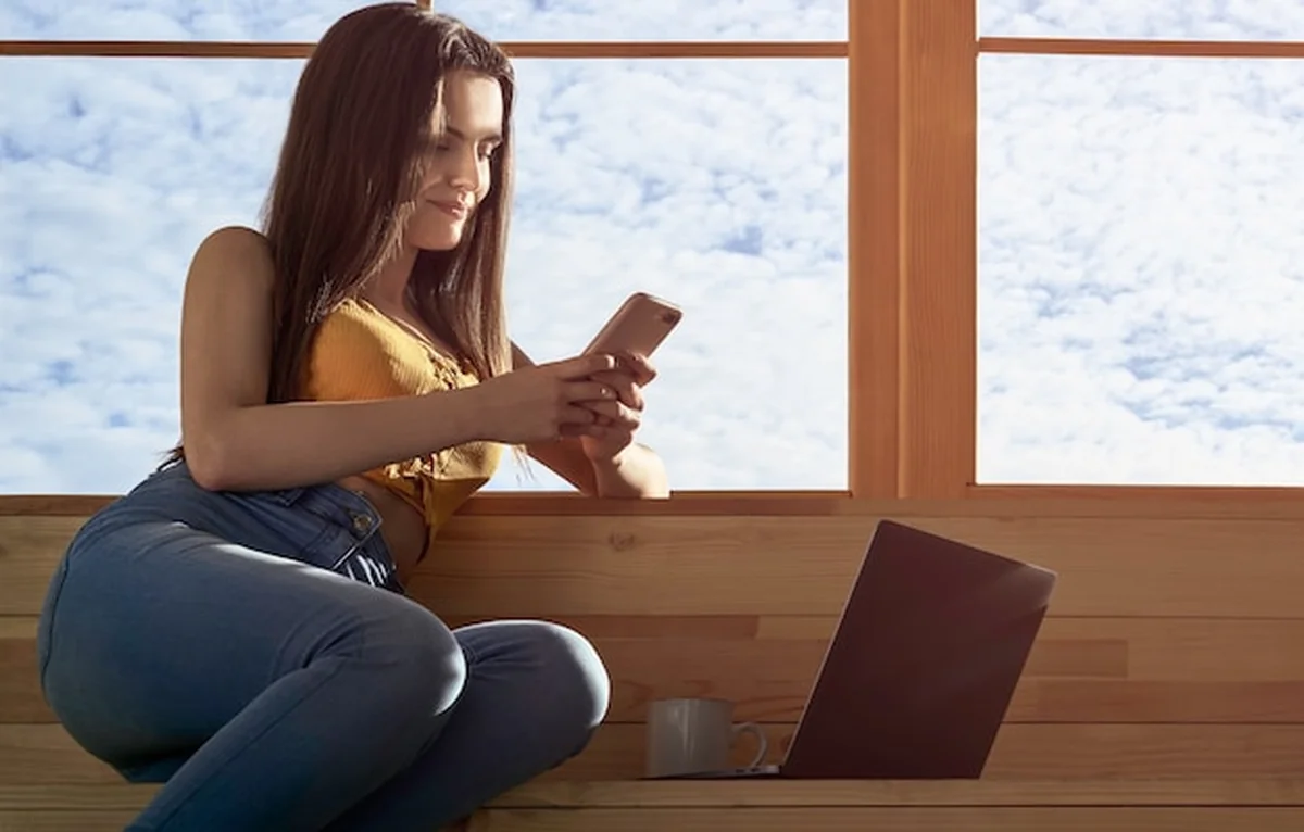 Kobieta używa smartfona i laptopa