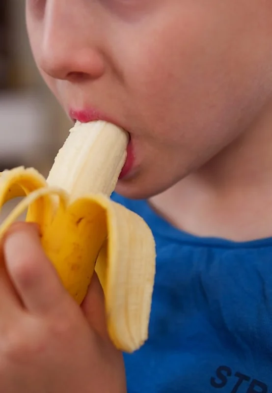Dziecko jedzące banan z apetytem