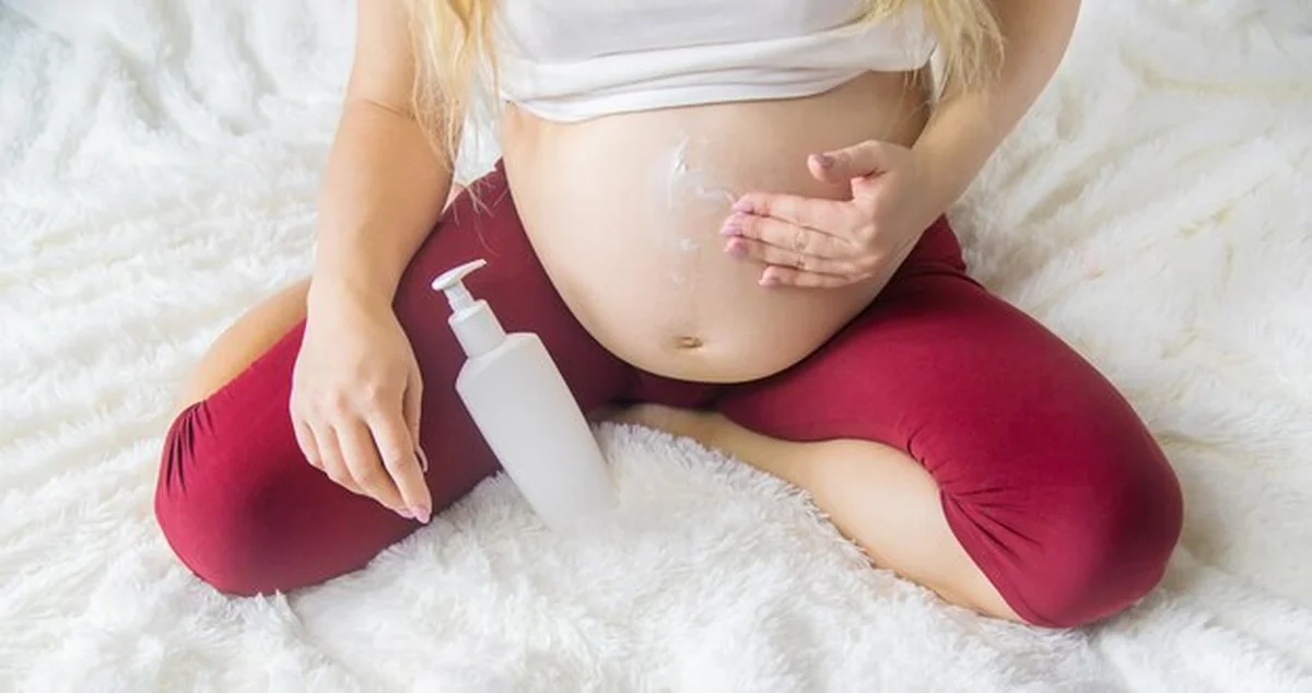 Kobieta w ciąży smaruje krem z rozstępów