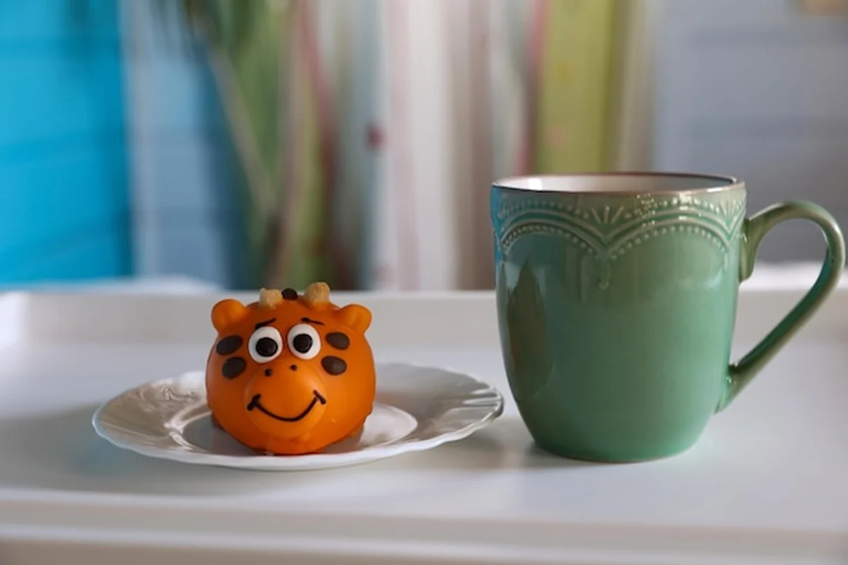 Delikatny deser z filiżanką herbaty i zabawnymi zwierzątkami