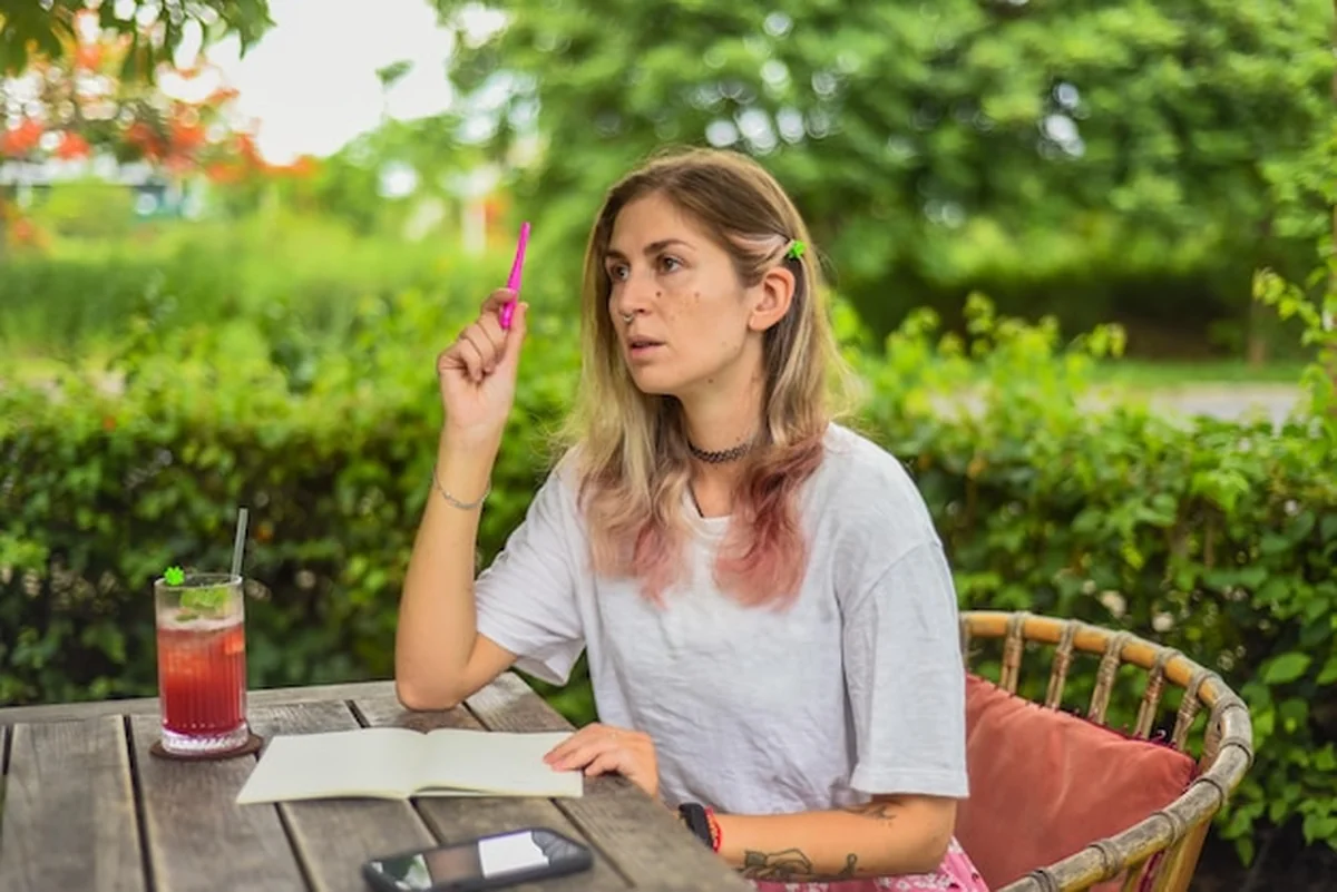 Kobieta pisząca w notatniku w ogrodzie