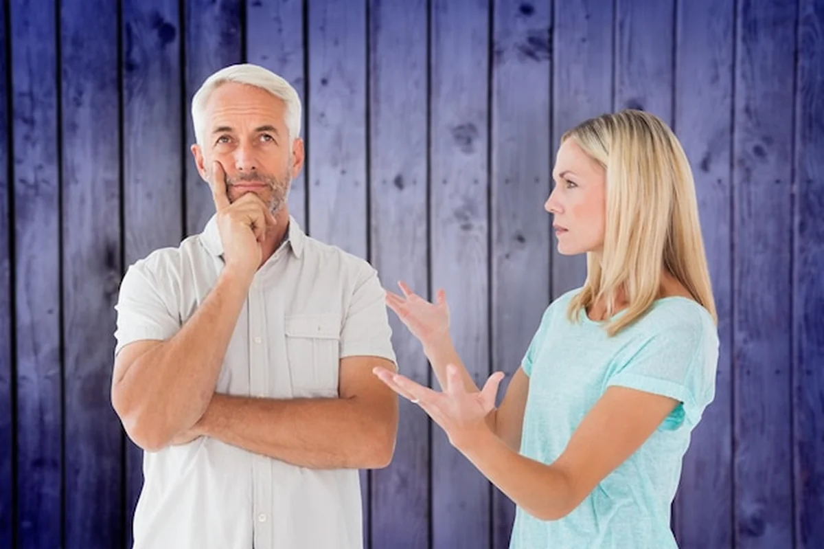 Nieszczęśliwa para kłóci się z mężczyzną na tle drewnianych desek