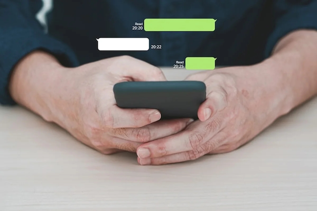 Człowiek korzystający z komunikatora na telefonie komórkowym