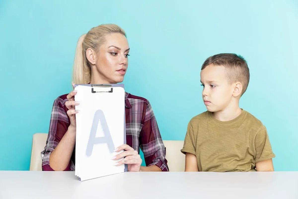 Matka pomaga synowi w odrabianiu prac domowych na białym tle różowym