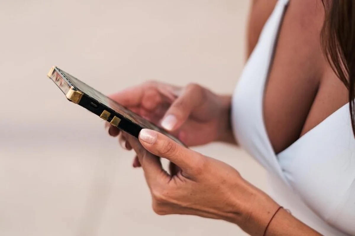 Kobieta używająca smartfona z paznokciem na spodzie dłoni